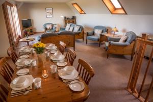 a dining room with a wooden table and chairs at Carden Holiday Cottages - Elgin in Crook of Alves