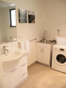 a bathroom with a sink and a washing machine at Wattletree Cottage in Halls Gap