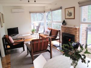a living room with a couch and a fireplace at Wattletree Cottage in Halls Gap