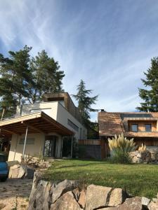 a house with a stone wall in front of it at Le Holzberg et ses Suites in Osenbach