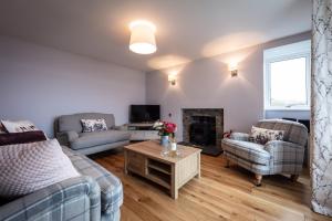 a living room with two couches and a fireplace at Lochside in Staffin