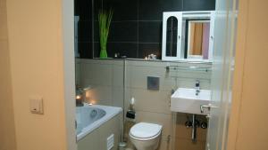 Łazienka z białą toaletą i umywalką w obiekcie Plenus Boutique Hotel w Bremie