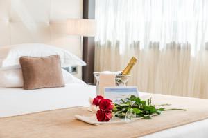 a tray with a bottle of champagne and flowers on a bed at Nixe Palace in Palma de Mallorca