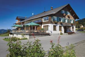 un gran edificio con porche y balcón en Gasthof Hirschen, en Sibratsgfäll