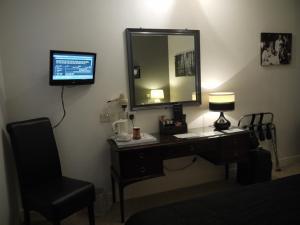 a desk with a mirror and a lamp and a chair at The Lodge in Barnby Dun