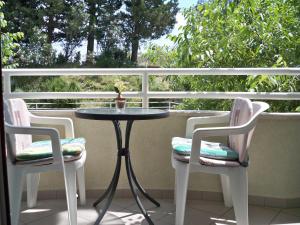 a small table and two chairs on a balcony at Apartmani Perkovic in Baška Voda