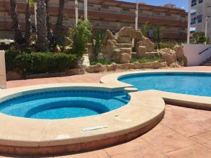 una piscina en un patio con un edificio en COSY FLATS 1ª LINEA VISTAS ESPECTACULARES, en Alicante
