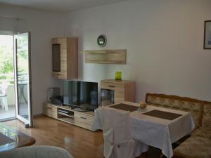 a living room with a table and a tv at Apartmani Perkovic in Baška Voda
