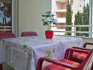 a table with a vase with a flower on it at Apartmani Perkovic in Baška Voda