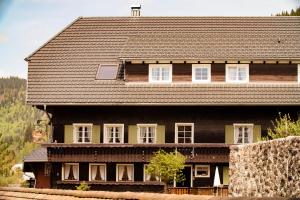 une grande maison en bois avec un toit marron dans l'établissement Gästehaus Erika, à Menzenschwand