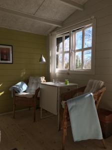 Heltoften Bed & Breakfast في نيكوبينغ مورس: غرفة بها كراسي وطاولة ونافذة