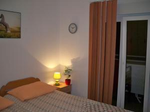 a bedroom with a bed and a clock on the wall at Apartmani Perkovic in Baška Voda