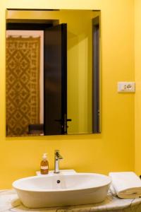 La salle de bains est pourvue d'un lavabo blanc et d'un miroir. dans l'établissement San Matteo 23, à Gênes