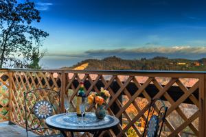 una mesa con 2 botellas de vino y flores en el balcón en Pizzicalaluna, en Pianoro