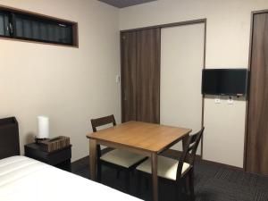 une chambre d'hôtel avec une table, des chaises et un lit dans l'établissement Kyogura Bettei Nijo, à Kyoto