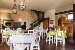 皮亚诺罗Pizzicalaluna Agriturismo Olistico sulle Colline di Pianoro的用餐室配有白色的桌子和白色的椅子