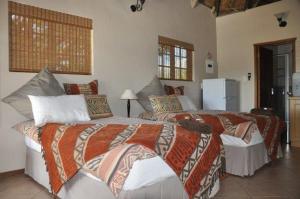 1 dormitorio con 2 camas y nevera en Dronfield Reserve en Kimberley