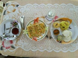 a table with two plates of food on it at Mist Valley in Masinagudi