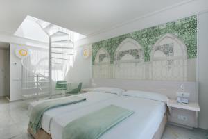 a white bedroom with a large bed and a window at Iberostar Selection Marbella Coral Beach in Marbella