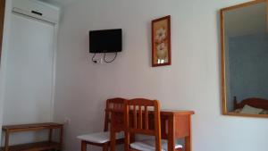 a room with a desk and a tv on a wall at Hostal Mini Golf in Los Caños de Meca