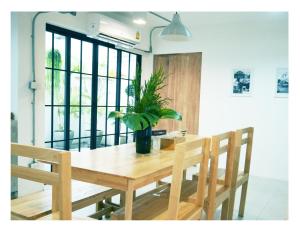 a dining room table with a potted plant on it at The Companion in Bangkok