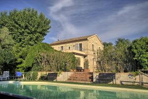 una casa con piscina di fronte a una casa di Grande villa storica per vacanze con giardino privato e piscina a Ostra