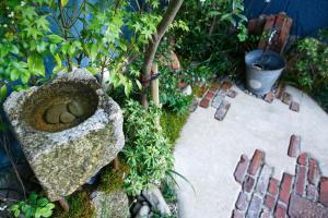 
a pottery pot sitting in the middle of a garden at Konyamachi Guest House Kuku in Takamatsu

