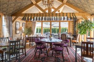 un comedor con mesas y sillas y una lámpara de araña en The Lion Bicester en Wendlebury