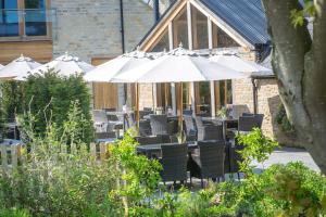 Un grupo de mesas y sillas con sombrillas. en The Lion Bicester, en Wendlebury