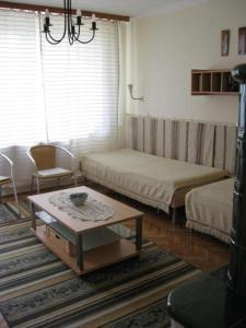 a living room with two beds and a coffee table at Liliom Apartments Balatonfüred in Balatonfüred