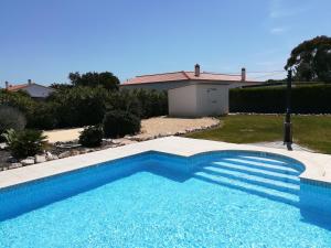 
a blue and white swimming pool in front of a house at Casa Sol in Aljezur
