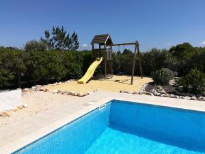 
a pool with a chair and a surfboard on top of it at Casa Sol in Aljezur
