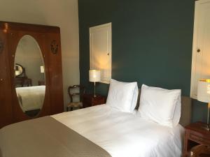 a bedroom with a white bed and a mirror at Apartment La Terasse in Carcassonne