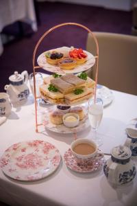 una mesa cubierta con una bandeja de sándwiches y una taza de té en Thistle London Holborn en Londres