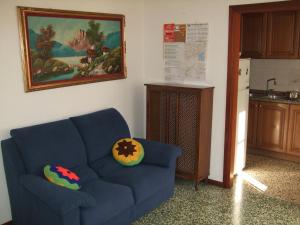 a living room with a blue couch and a kitchen at Venice Lagoon House B&B in Tessera