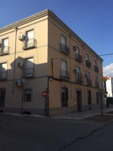 un grand bâtiment sur le côté d'une rue dans l'établissement Hostal La Estación, à Tarancón