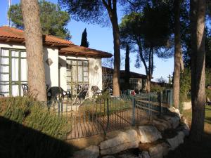 a fence in front of a house with trees at Shoresh Green Hills in Shoresh