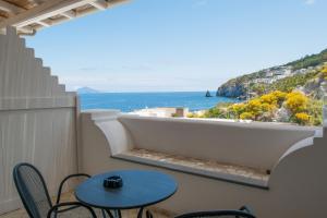 uma varanda com uma mesa e vista para o oceano em Hotel Cutimare - Aeolian Charme em Acquacalda