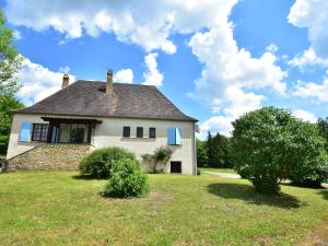 ein weißes Haus auf einem grünen Feld mit blauem Himmel in der Unterkunft Cosy holiday home in Lantheuil with garden in Villefranche-du-Périgord
