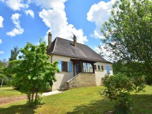ein kleines weißes Haus auf einem Hügel mit Bäumen in der Unterkunft Cosy holiday home in Lantheuil with garden in Villefranche-du-Périgord