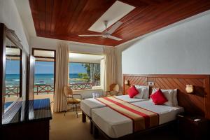 una camera da letto con un letto con vista sull'oceano di Coral Sands Hotel a Hikkaduwa