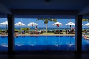 a swimming pool with a view of the ocean at Coral Sands Hotel in Hikkaduwa