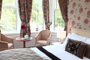 a bedroom with a bed and a table and windows at Best Western New Kent Hotel in Newcastle upon Tyne