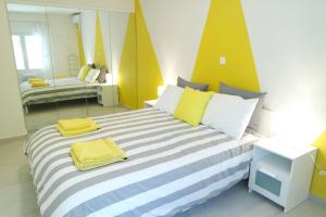 Un dormitorio con una cama grande con almohadas amarillas y blancas. en Design Apartment in the City of Athens, en Atenas