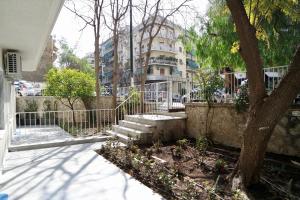 un árbol y escaleras delante de un edificio en Design Apartment in the City of Athens, en Atenas