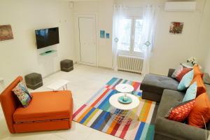 una sala de estar con un sofá y una silla en Design Apartment in the City of Athens, en Atenas