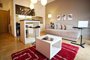 a living room with a white couch and a red rug at Boutique Apartments 360º in Belgrade