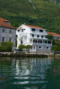 a large white building next to a body of water at Apartments Popovic in Kotor +51 photos