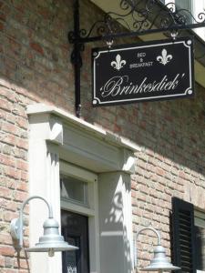 een bord aan de zijkant van een bakstenen gebouw bij Brinkesdiek in Hardenberg