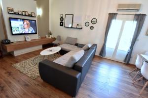 uma sala de estar com um sofá e uma televisão em Apartment Popek Opatija em Opatija